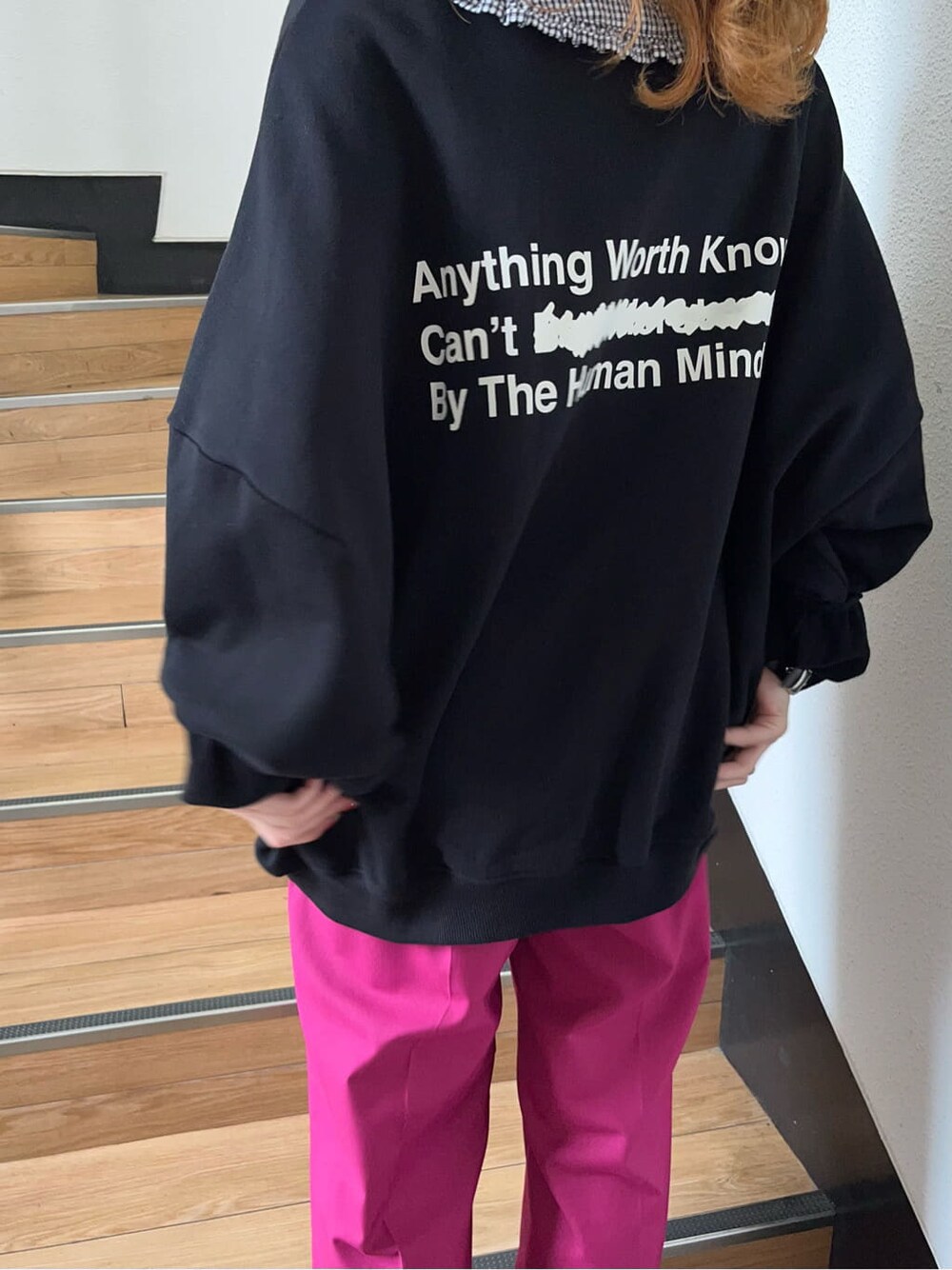 ピンク系のスラックス、ブラック系のスウェットを着用したレディースの冬コーディネートの3枚目の写真