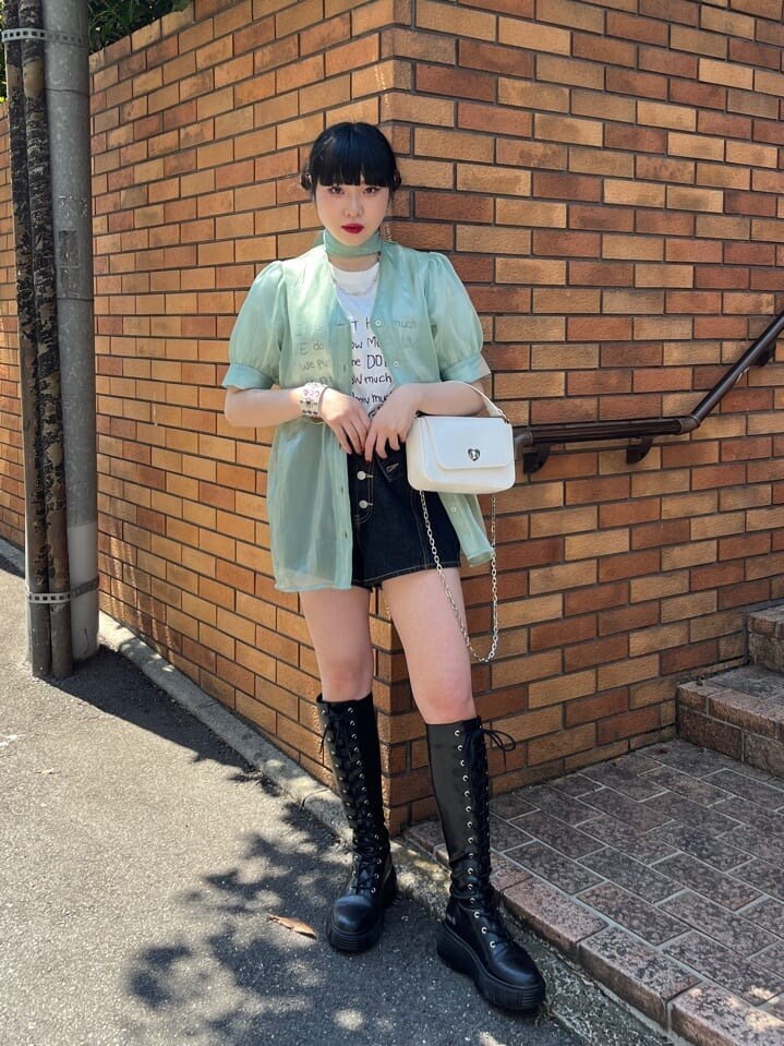 ブラック系のブーツ、ブラック系のデニムパンツ、グリーン系のシャツ/ブラウスを着用したレディースの春コーディネートの2枚目の写真