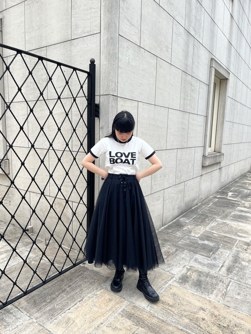 ホワイト系のTシャツ/カットソー、ブラック系のスカート、シルバー系のネックレスを着用したレディースの夏コーディネートの2枚目の写真