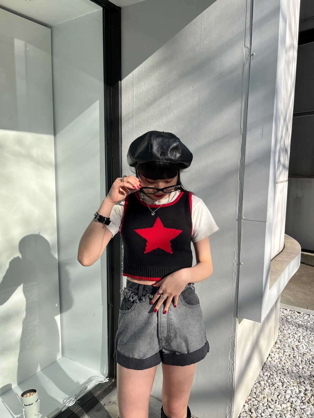 ブラック系のタンクトップ、ブルー系のデニムパンツ、ブラック系のハンチング/ベレー帽を着用したレディースの冬コーディネートの4枚目の写真