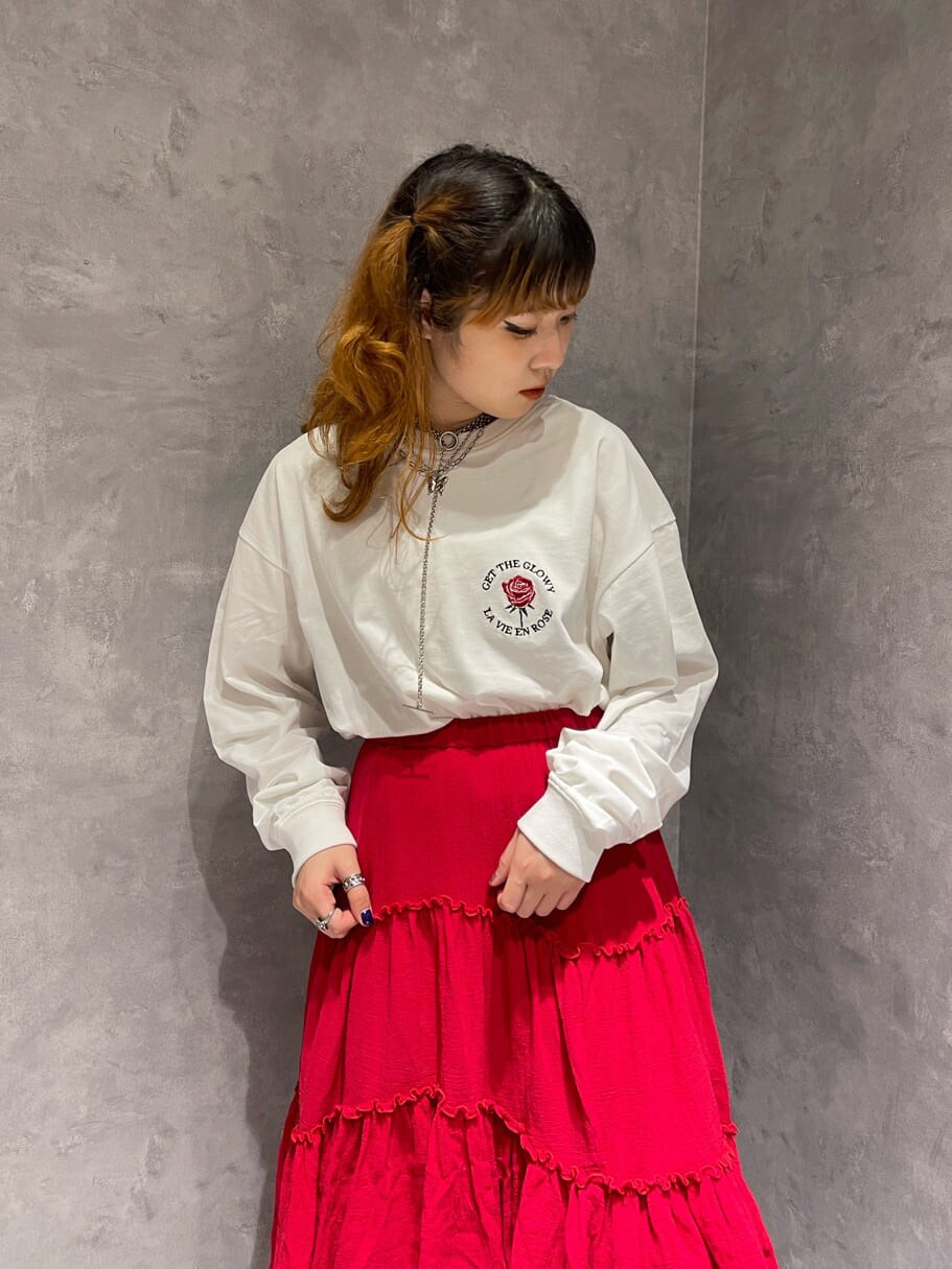 レッド系のスカート、ホワイト系のブーツ、ホワイト系のTシャツ/カットソーを着用したレディースの夏コーディネートの2枚目の写真