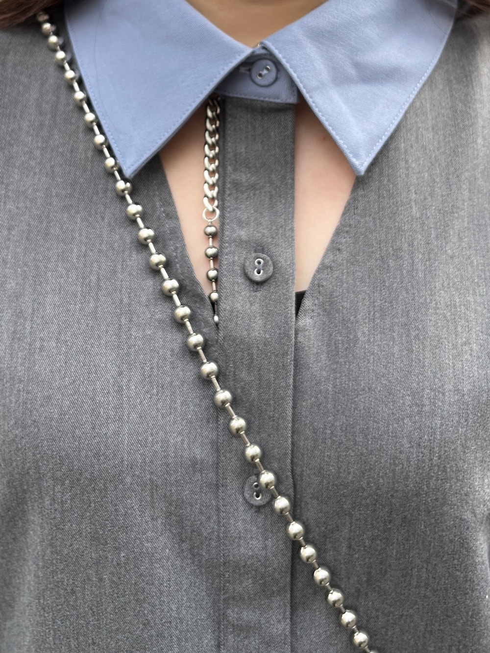 グレー系のワンピース、ブラック系のブーツ、ホワイト系のショルダーバッグを着用したレディースの冬コーディネートの7枚目の写真