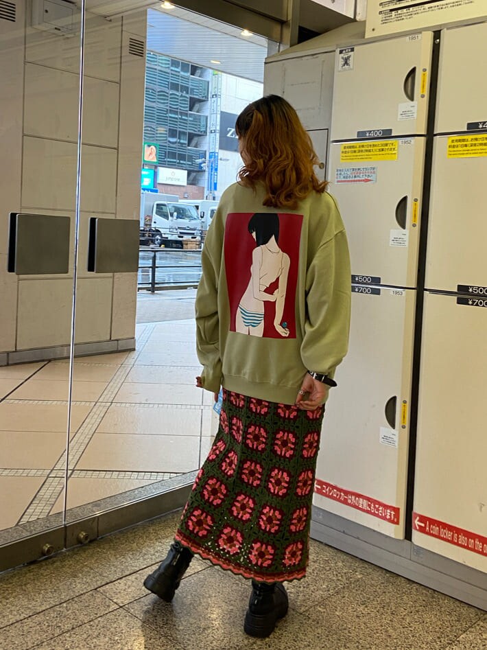 グリーン系のスカート、グリーン系のスウェットを着用したレディースの秋コーディネートの2枚目の写真