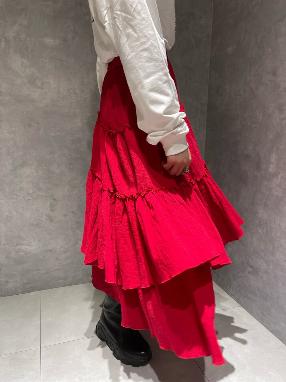 レッド系のスカート、ホワイト系のブーツ、ホワイト系のTシャツ/カットソーを着用したレディースの夏コーディネートの5枚目の写真