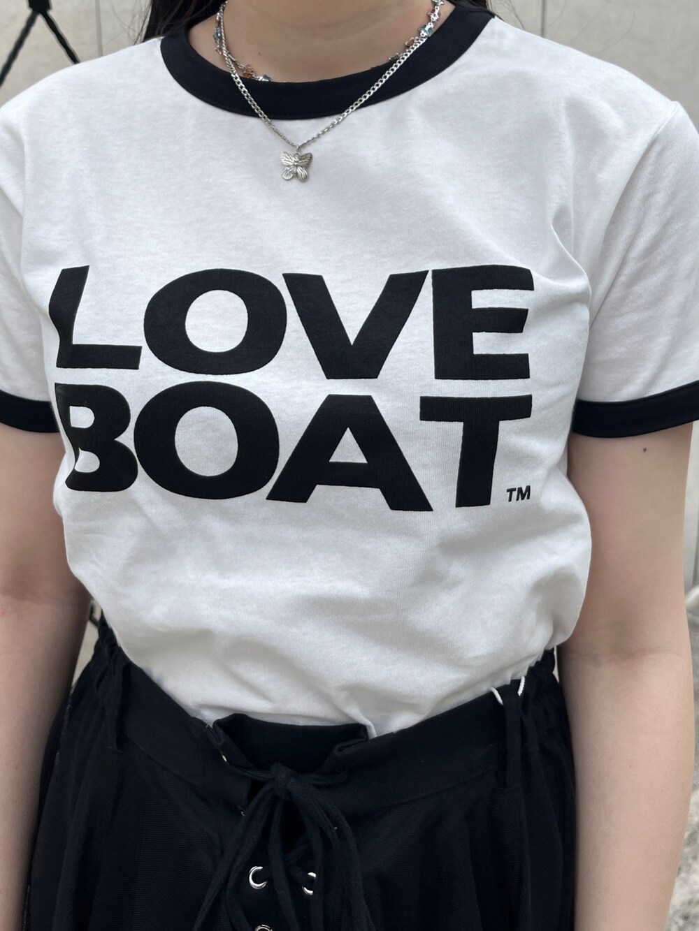 ホワイト系のTシャツ/カットソー、ブラック系のスカート、シルバー系のネックレスを着用したレディースの夏コーディネートの5枚目の写真