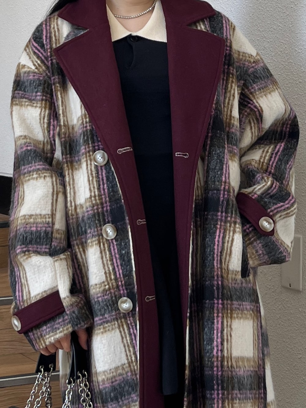 ブラック系のブーツ、ブラック系のハンドバッグ、ホワイト系のチェスターコートを着用したレディースの夏コーディネートの4枚目の写真