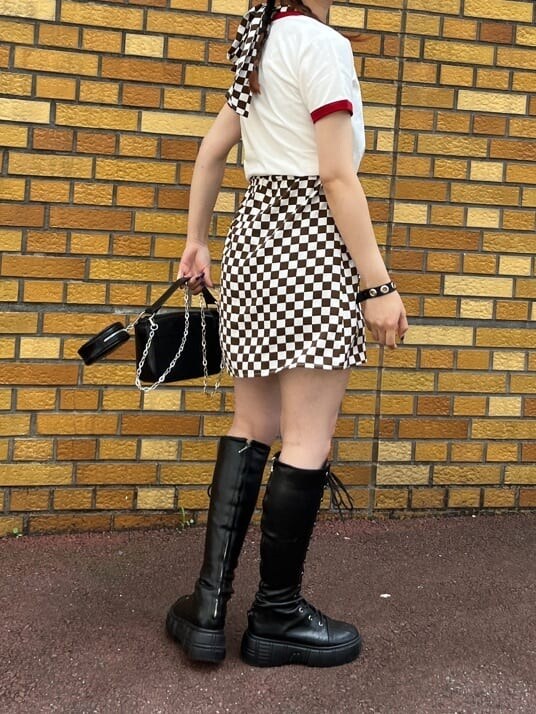 ブラック系のブーツ、ホワイト系のシャツ/ブラウス、ブラック系のハンドバッグを着用したレディースの夏コーディネートの4枚目の写真