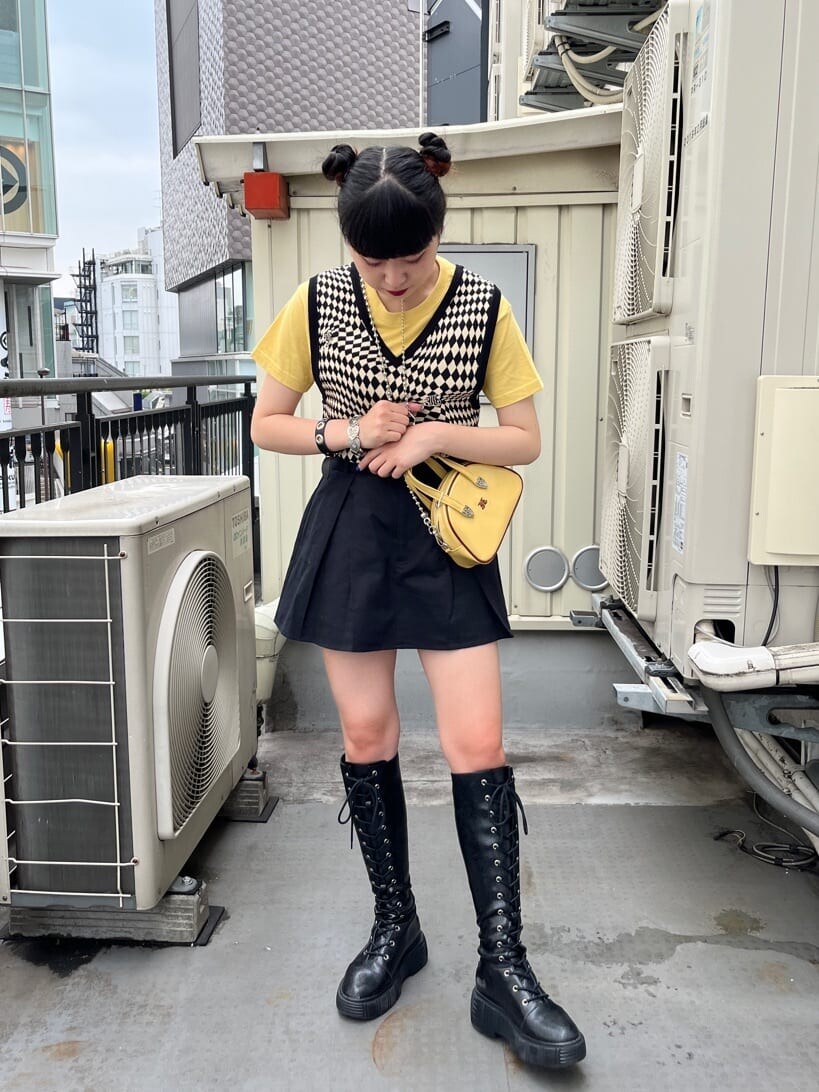 ブラック系のブーツ、ブラック系のニット/セーター、イエロー系のTシャツ/カットソーを着用したレディースの夏コーディネートの2枚目の写真