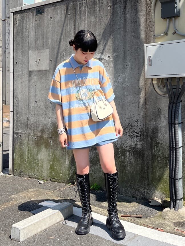 ブラック系のブーツ、ブルー系のその他パンツ、ホワイト系のボストンバッグを着用したレディースの春コーディネートの2枚目の写真