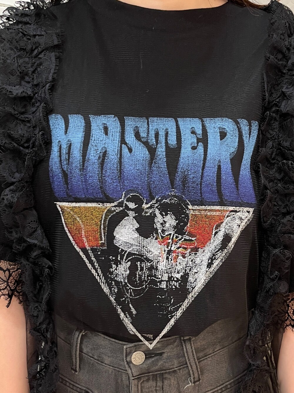 ブラック系のワンピース、ブラック系のブーツ、ブラック系のデニムパンツを着用したレディースの春コーディネートの6枚目の写真