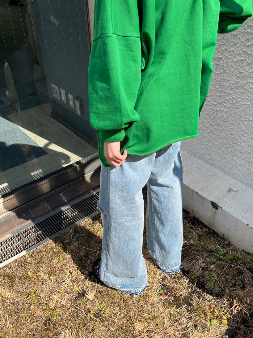 ブルー系のデニムパンツ、グリーン系のスウェットを着用したレディースの春コーディネートの5枚目の写真