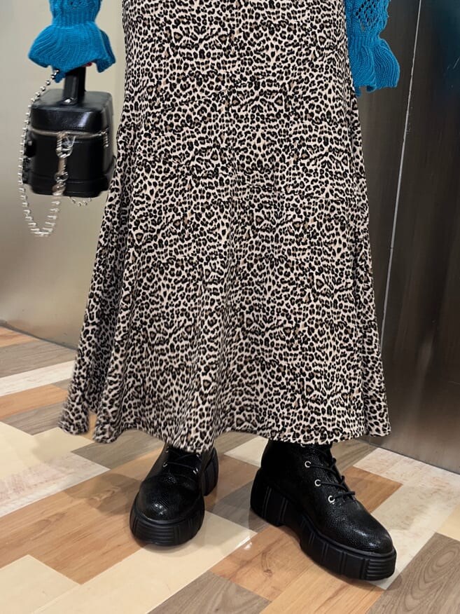 ブラウン系のスカート、ブラック系のショルダーバッグ、ブルー系のカーディガン/ボレロを着用したレディースの冬コーディネートの4枚目の写真