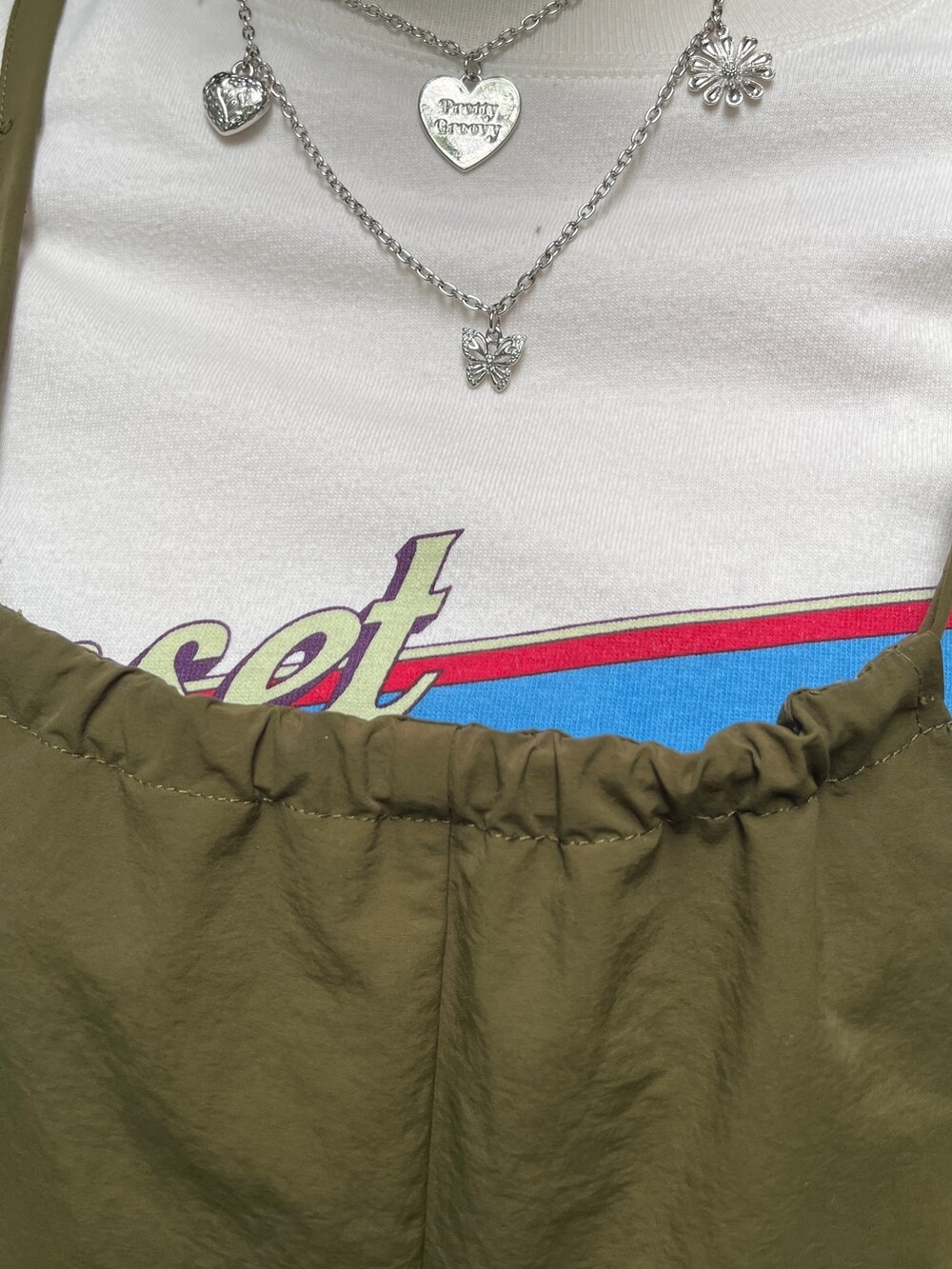 ホワイト系のTシャツ/カットソー、ブラック系のブーツ、ブラック系のアームカバーを着用したレディースの夏コーディネートの5枚目の写真