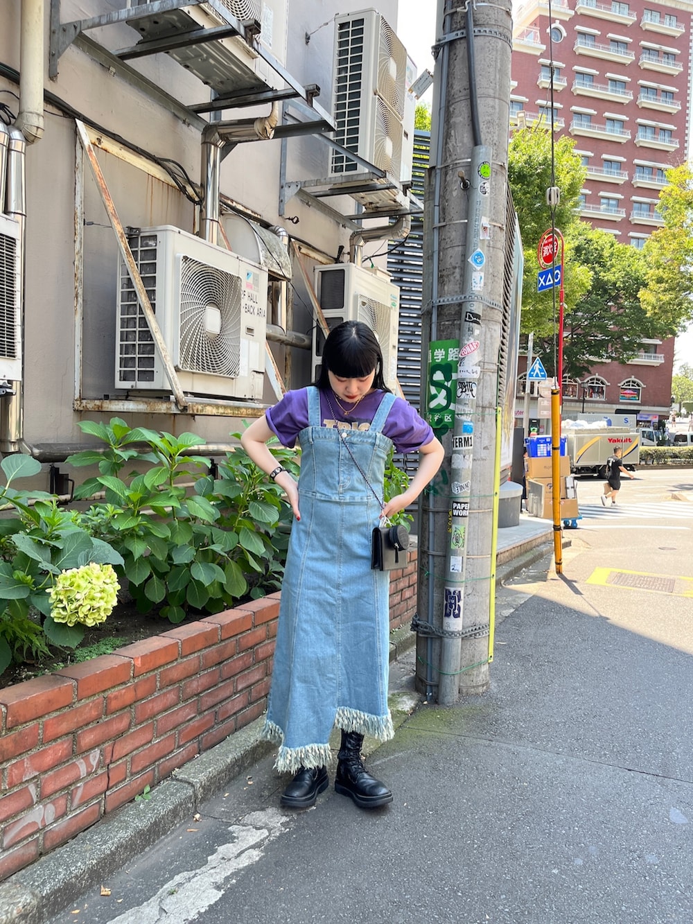 ブルー系のジャンパースカート、ブラック系のショルダーバッグ、ホワイト系のTシャツ/カットソーを着用したレディースの夏コーディネートの3枚目の写真