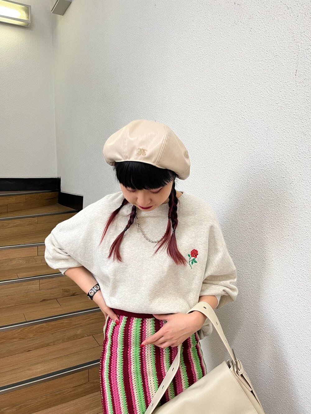 レッド系のスカート、グレー系のTシャツ/カットソー、ブラック系のブーツを着用したレディースの秋コーディネートの4枚目の写真