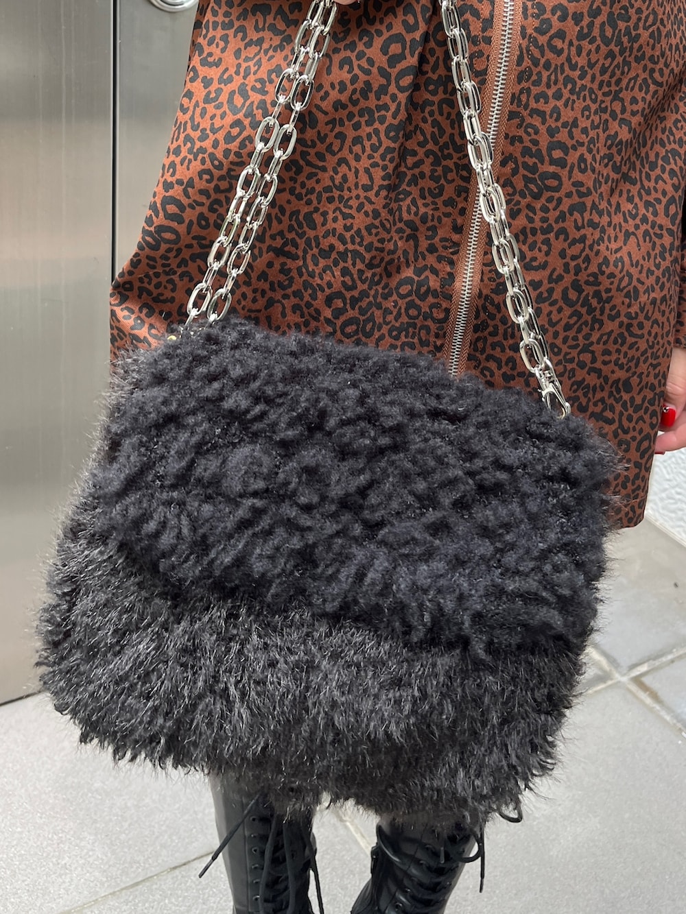 ブラック系のブーツ、ブラウン系のワンピース、ブラック系のハンドバッグを着用したレディースの夏コーディネートの7枚目の写真