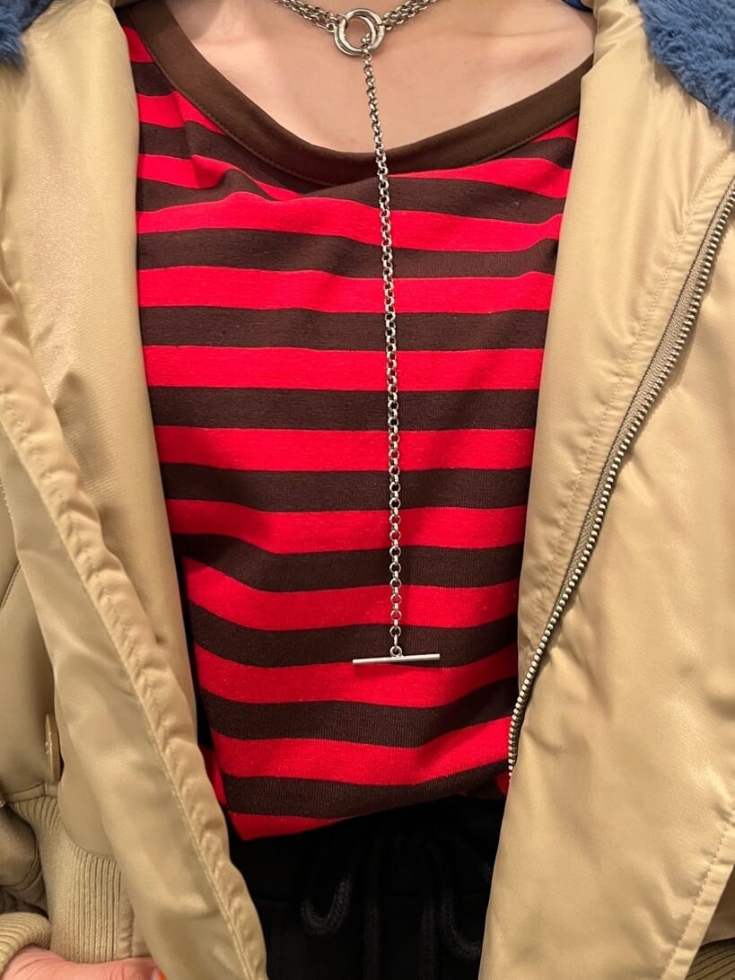 レッド系のTシャツ/カットソー、ベージュ系のその他アウター、ブラック系のスカートを着用したレディースの秋コーディネートの5枚目の写真