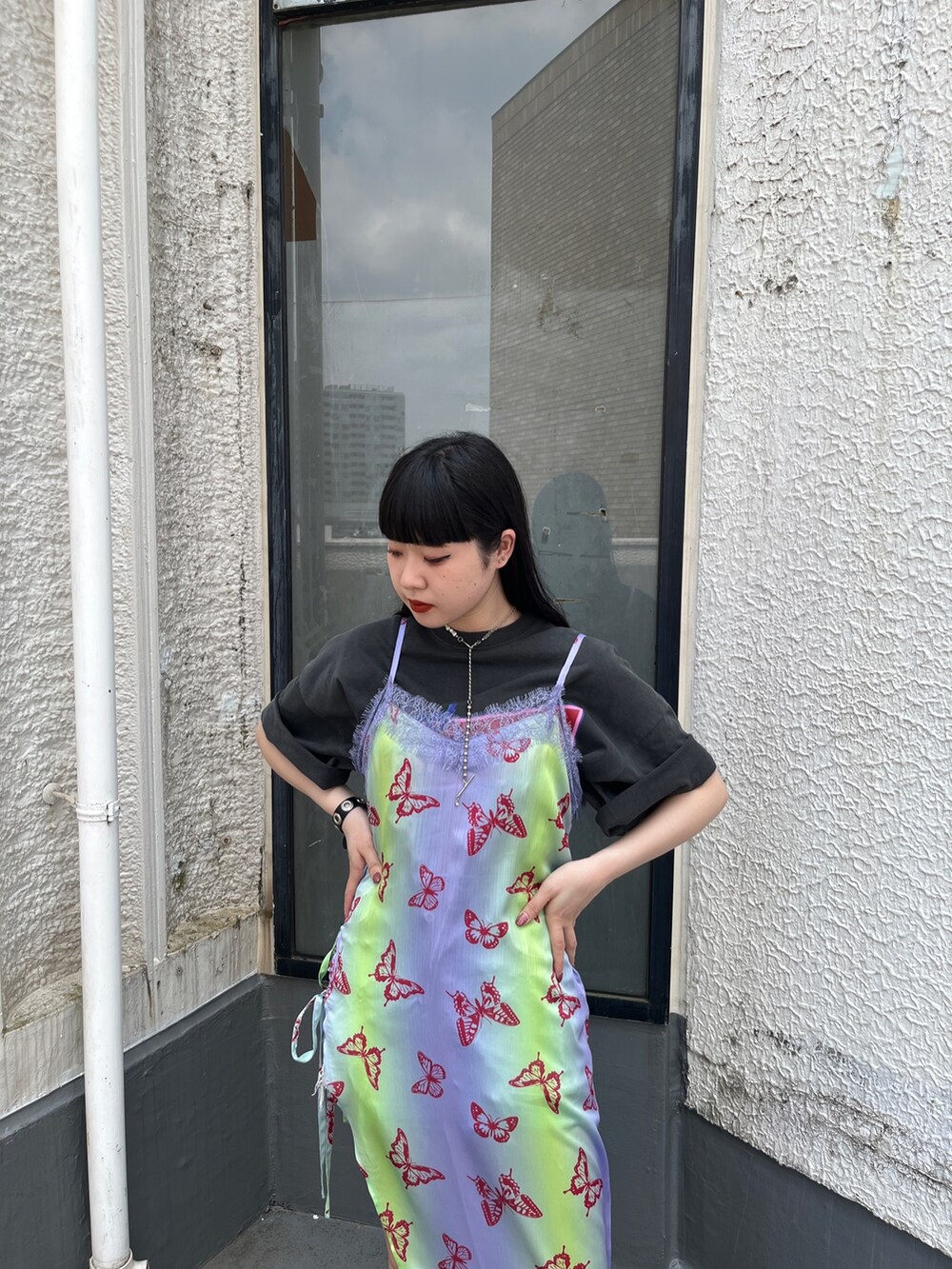 パープル系のワンピース、ブラック系のTシャツ/カットソー、ブラック系のブーツを着用したレディースの春コーディネートの4枚目の写真