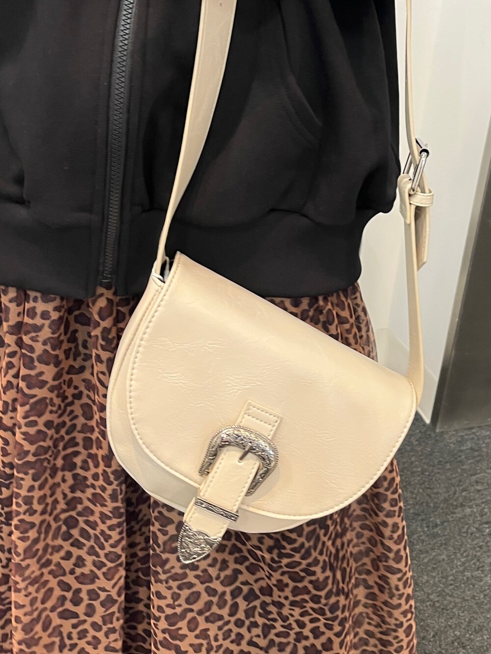 その他のスカート、ブラック系のパーカー、ホワイト系のショルダーバッグを着用したレディースの冬コーディネートの8枚目の写真