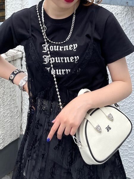 ブラック系のワンピース、ブラック系のデニムパンツ、ホワイト系のボストンバッグを着用したレディースの夏コーディネートの5枚目の写真