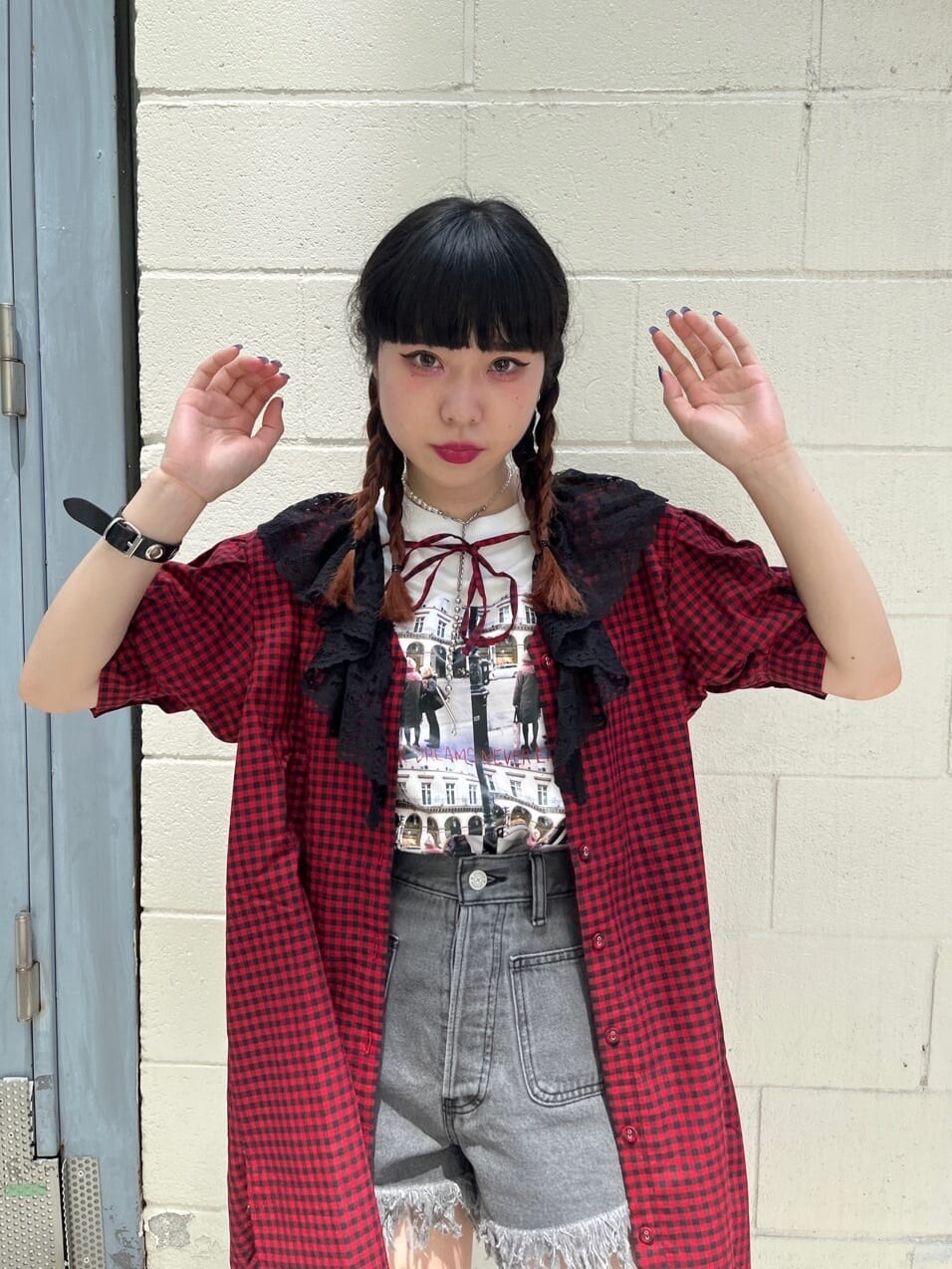 レッド系のシャツ/ブラウス、ブラック系のデニムパンツ、ブラック系のブーツを着用したレディースの夏コーディネートの2枚目の写真