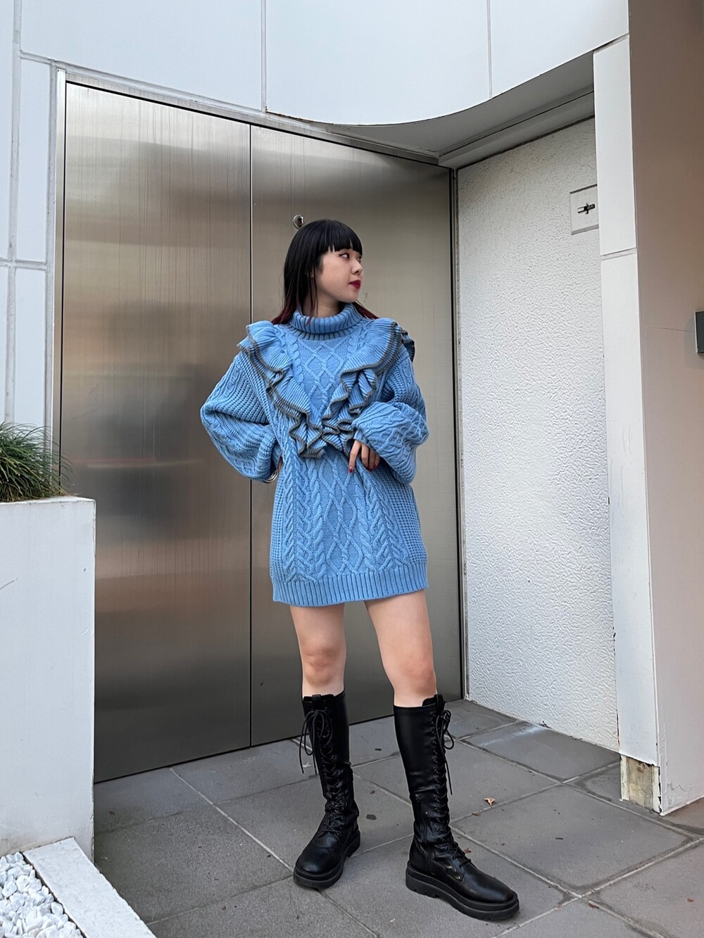 ブルー系のニット/セーター、ブラック系のブーツを着用したレディースの冬コーディネートの3枚目の写真