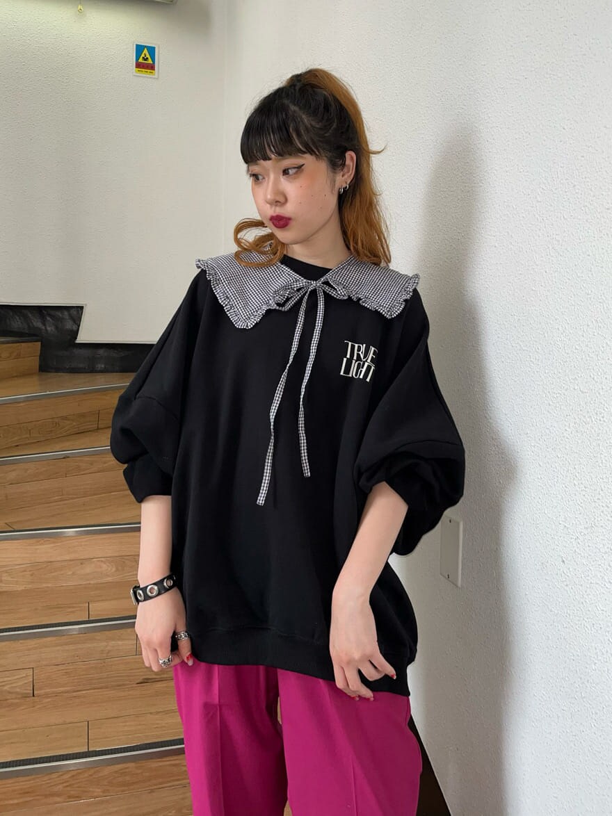 ピンク系のスラックス、ブラック系のスウェットを着用したレディースの冬コーディネートの2枚目の写真