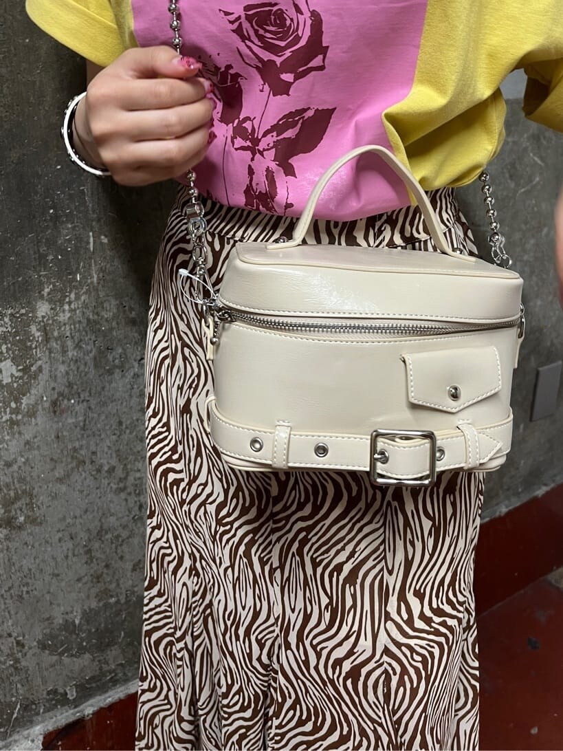 ブラック系のブーツ、ホワイト系のショルダーバッグ、その他のスカートを着用したレディースの春コーディネートの4枚目の写真