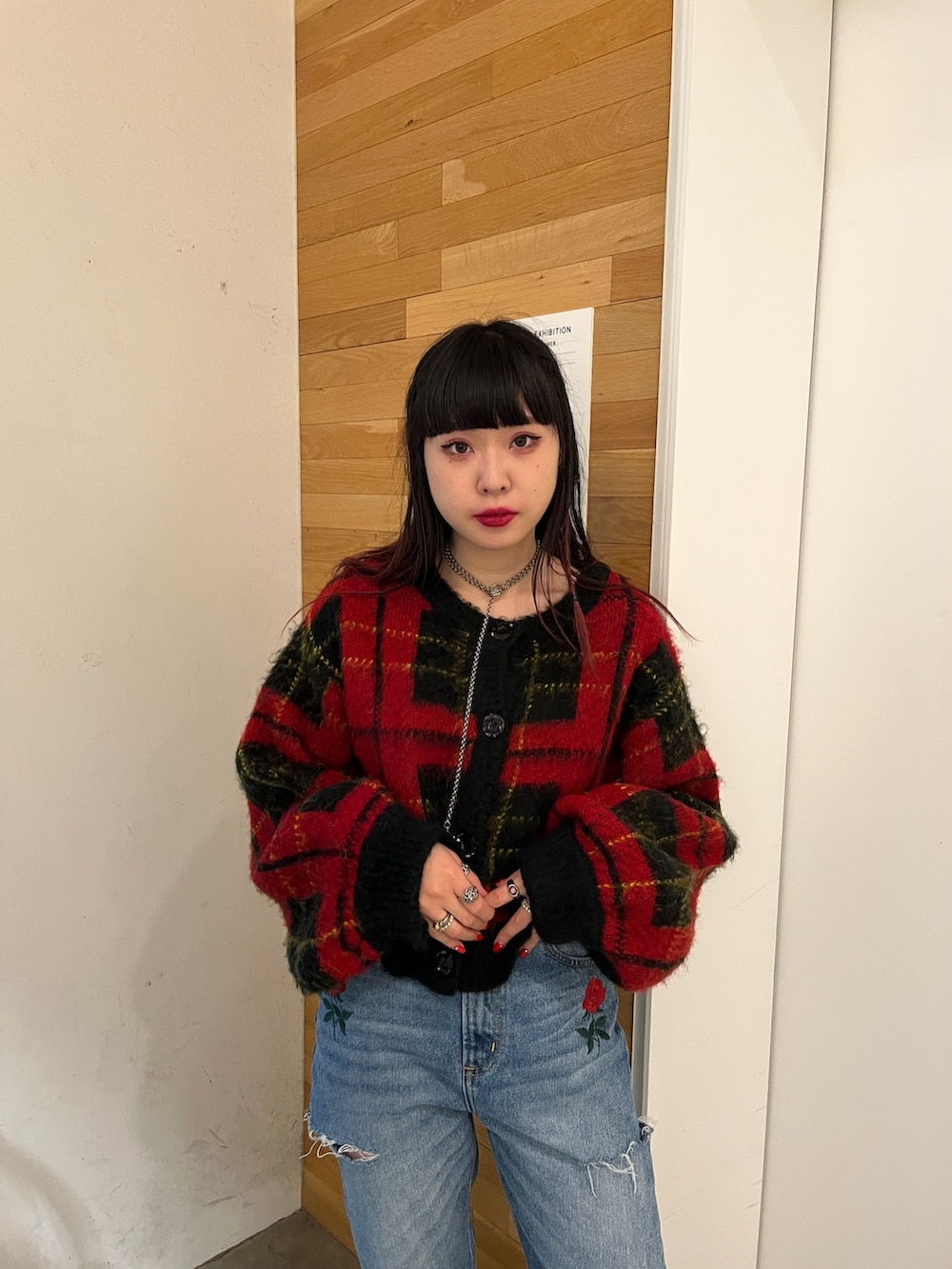 ブラック系のその他シューズ、レッド系のカーディガン/ボレロ、ブルー系のデニムパンツを着用したレディースの秋コーディネートの3枚目の写真