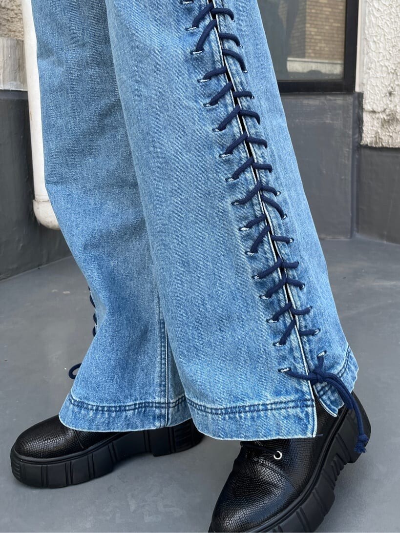 ブラック系のブーツ、ホワイト系のTシャツ/カットソー、ブルー系のデニムパンツを着用したレディースの春コーディネートの6枚目の写真