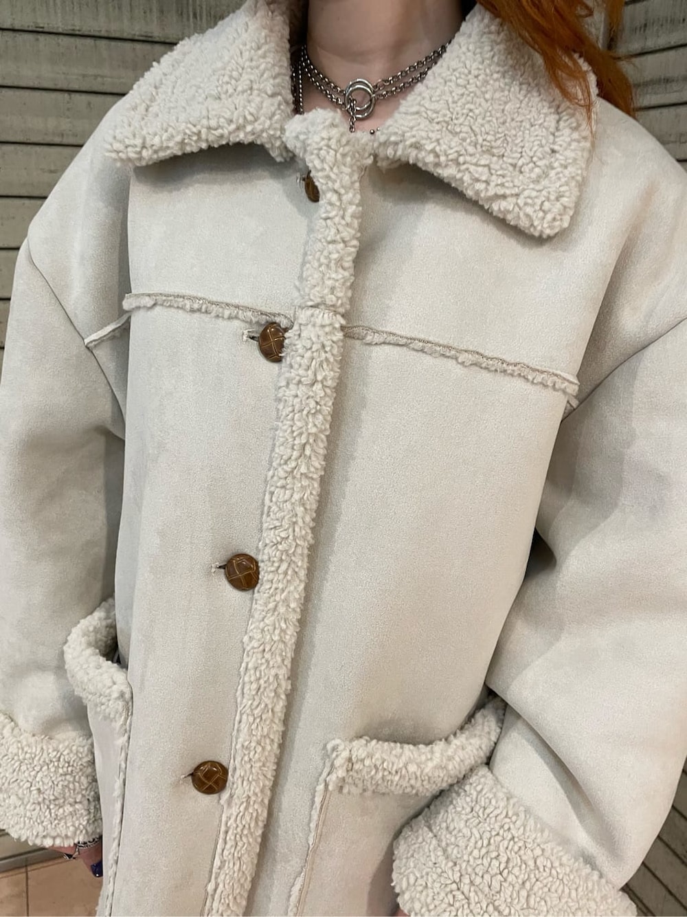 グリーン系のブーツ、ホワイト系のムートンコートを着用したレディースの夏コーディネートの4枚目の写真