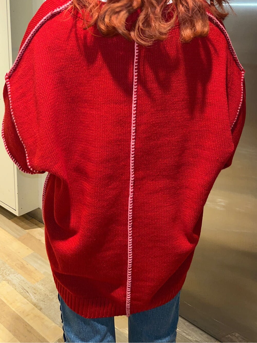 レッド系のニット/セーター、ホワイト系のTシャツ/カットソーを着用したレディースの冬コーディネートの5枚目の写真