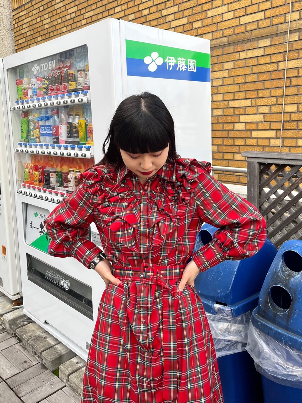 レッド系のワンピース、ブラック系のブーツを着用したレディースの冬コーディネートの4枚目の写真