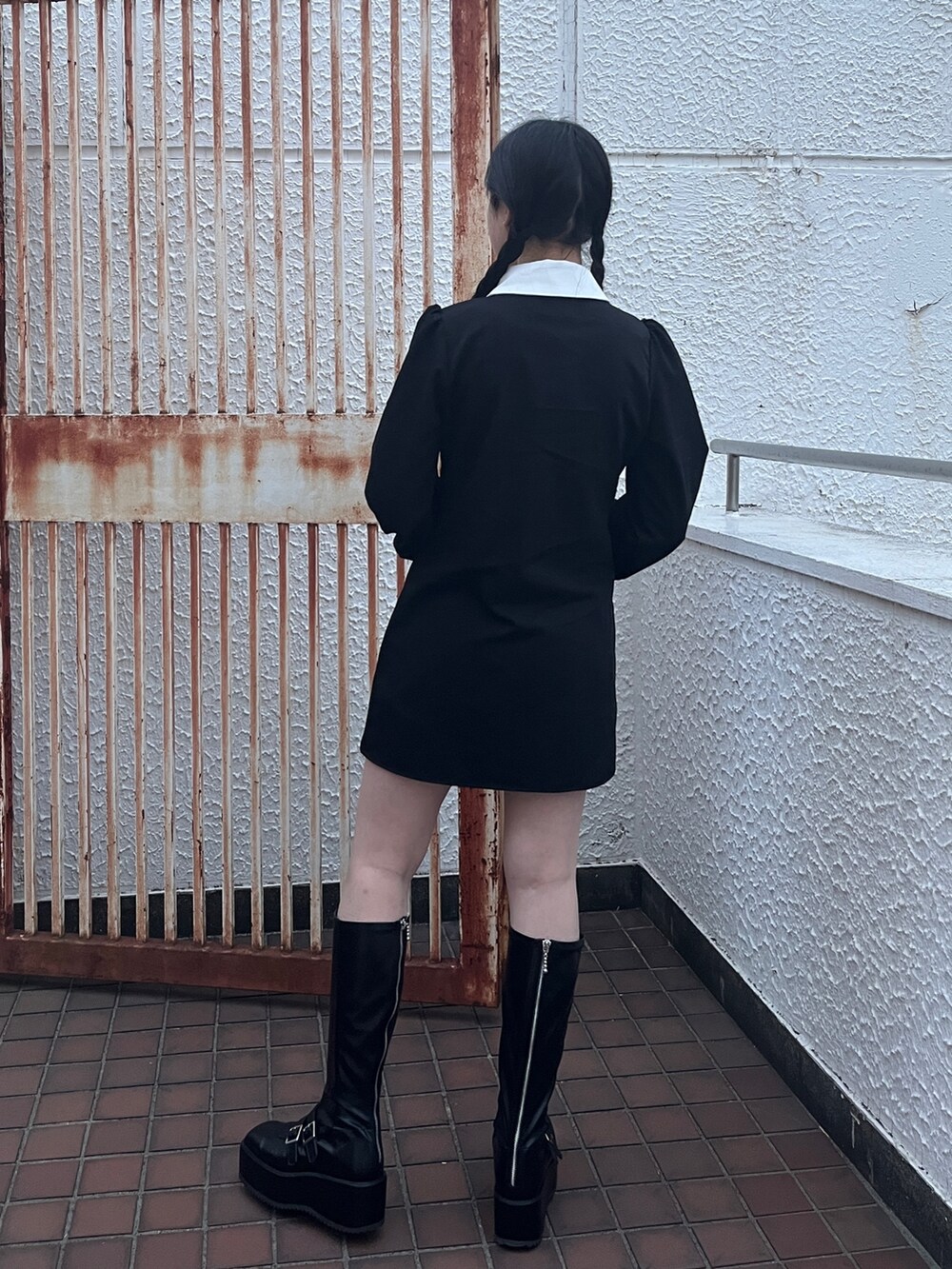 ブラック系のワンピース、ブラック系のブーツを着用したレディースの冬コーディネートの4枚目の写真