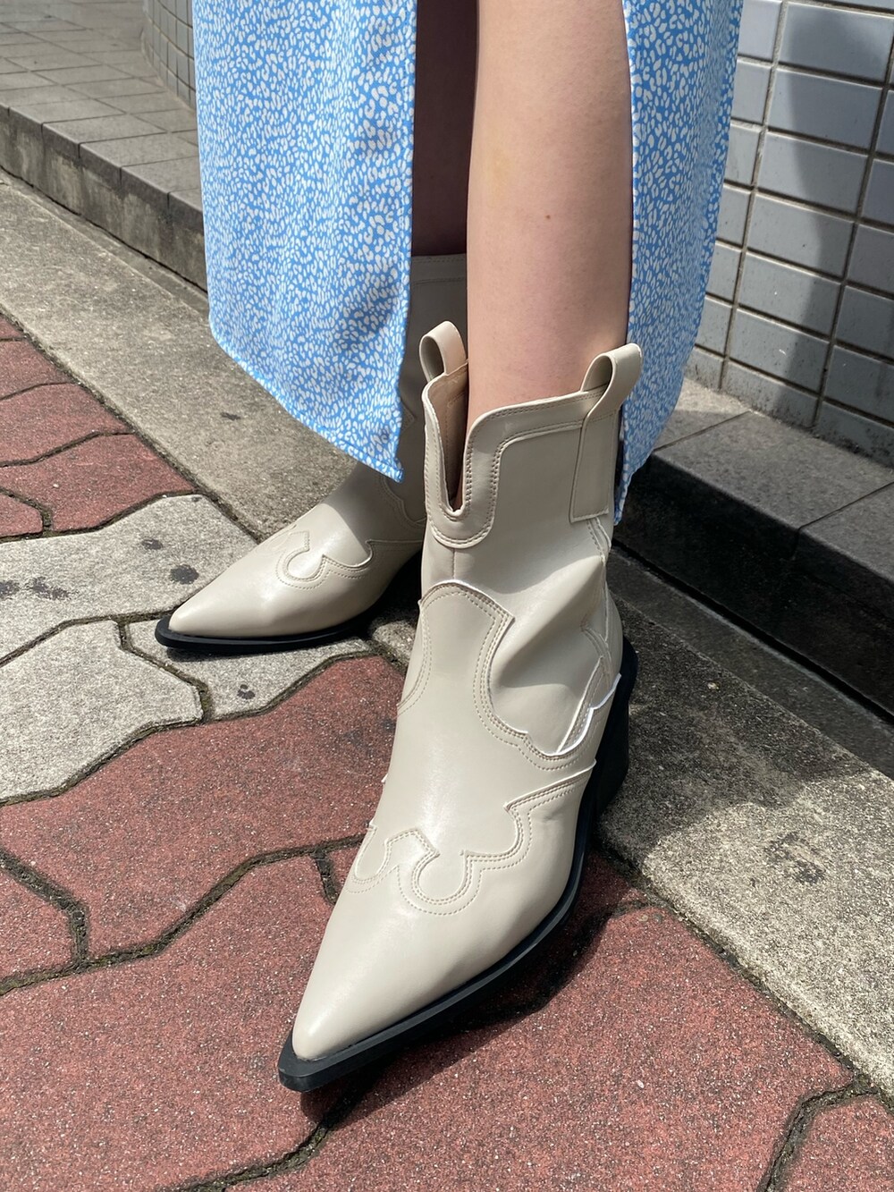 ホワイト系のブーツ、ホワイト系のスカート、ブルー系のタンクトップを着用したレディースの春コーディネートの9枚目の写真