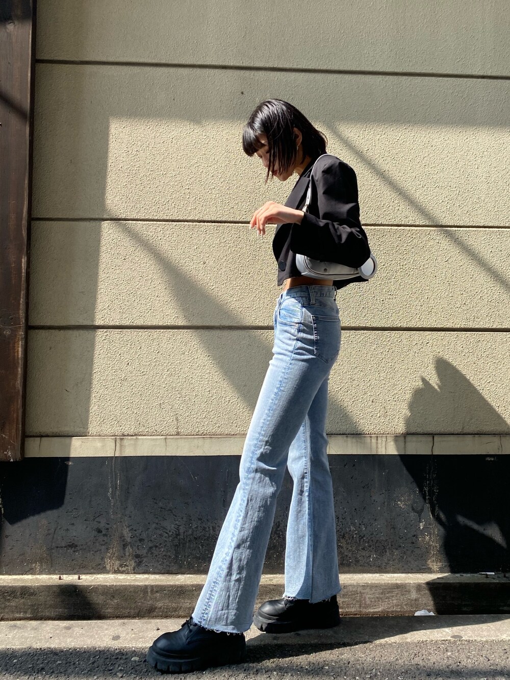 ブラック系のブーツ、ブルー系のデニムパンツ、ブラック系のTシャツ/カットソーを着用したレディースの春コーディネートの4枚目の写真