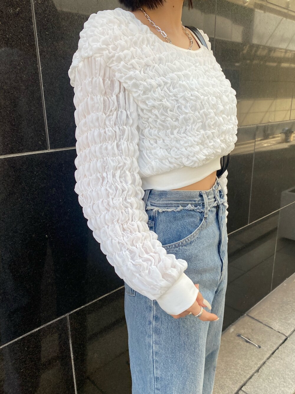 ブルー系のデニムパンツ、ブラック系のブーツ、ホワイト系のTシャツ/カットソーを着用したレディースの春コーディネートの9枚目の写真