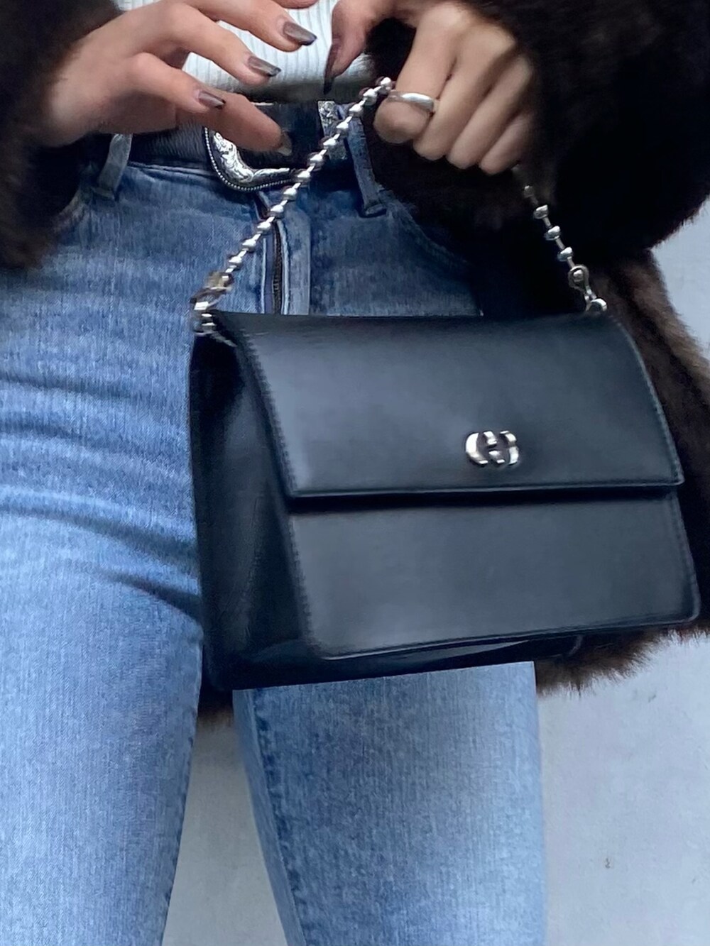 ブルー系のデニムパンツ、ブラック系のブーツ、ブラウン系のその他アウターを着用したレディースの冬コーディネートの6枚目の写真