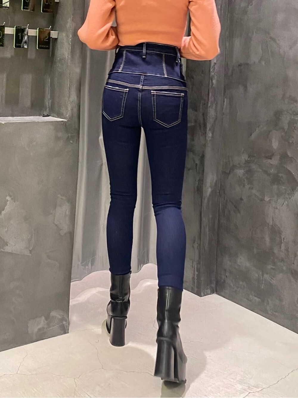 ブラック系のブーツ、ブルー系のデニムパンツ、ピンク系のニット/セーターを着用したレディースの秋コーディネートの4枚目の写真