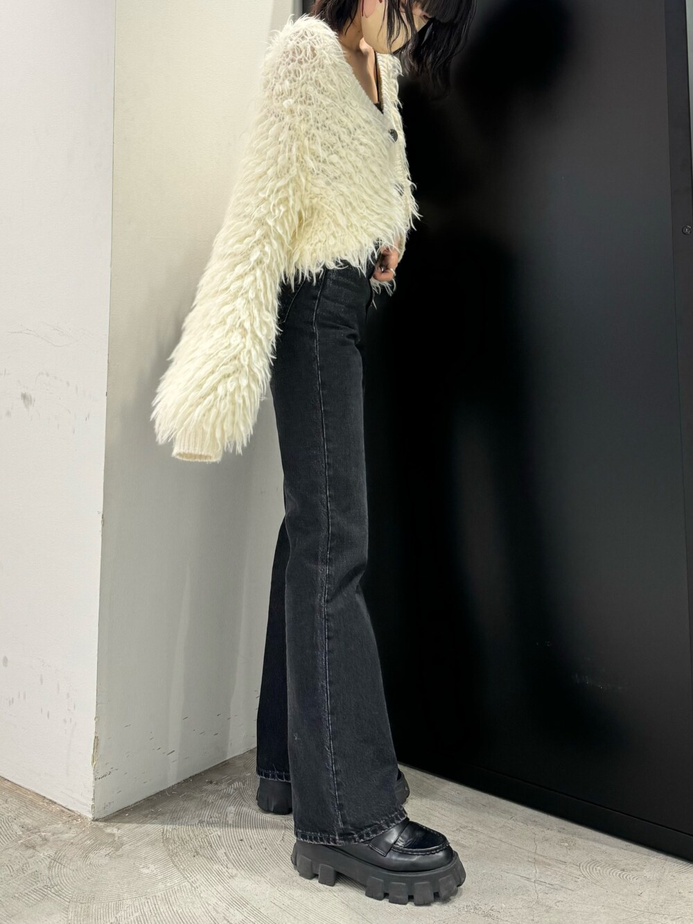 ブラック系のデニムパンツ、ホワイト系のカーディガン/ボレロを着用したレディースの秋コーディネートの3枚目の写真