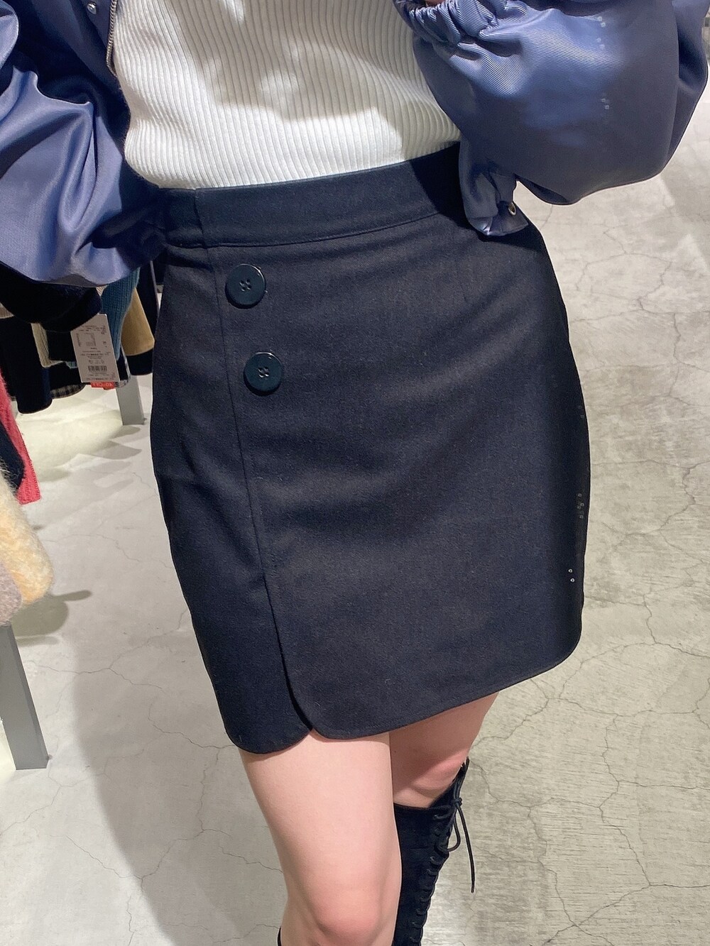 ブラック系のスカート、ブラック系のブーツ、グレー系のブルゾンを着用したレディースの冬コーディネートの7枚目の写真