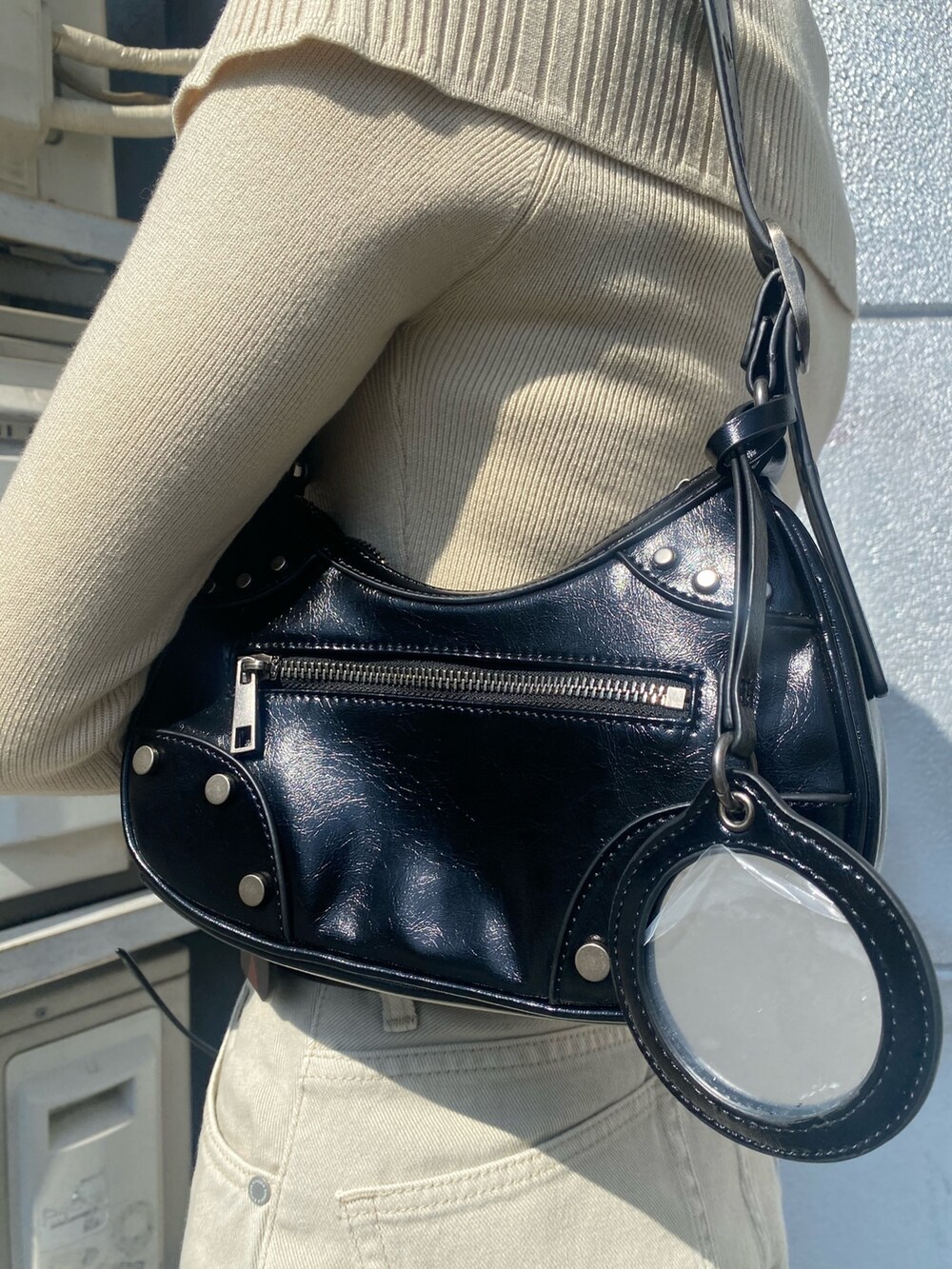 ブラウン系のブーツ、ホワイト系のデニムパンツ、ブラック系のハンドバッグを着用したレディースの春コーディネートの9枚目の写真