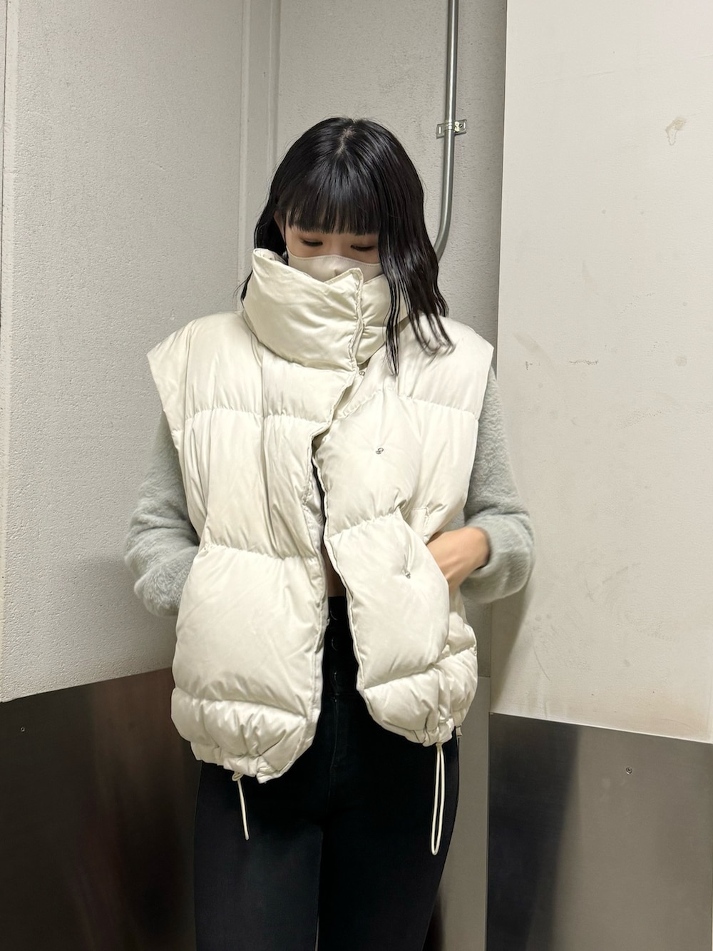 ブラック系のブーツ、ブラック系のデニムパンツ、グレー系のニット/セーターを着用したレディースの冬コーディネートの9枚目の写真