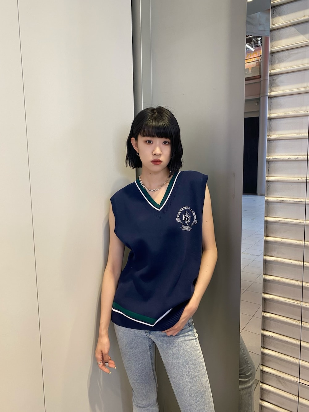 ブラック系のサンダル、ブルー系のデニムパンツ、ブルー系のベストを着用したレディースの春コーディネートの5枚目の写真