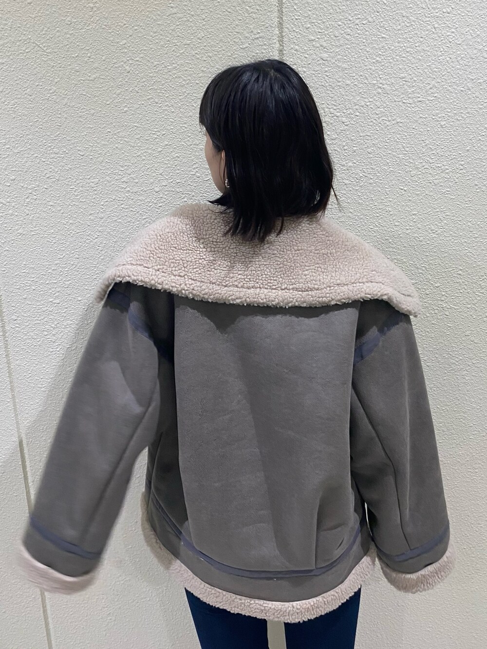 ブルー系のデニムパンツ、グレー系のブルゾン、ブラック系のニット/セーターを着用したレディースの冬コーディネートの7枚目の写真