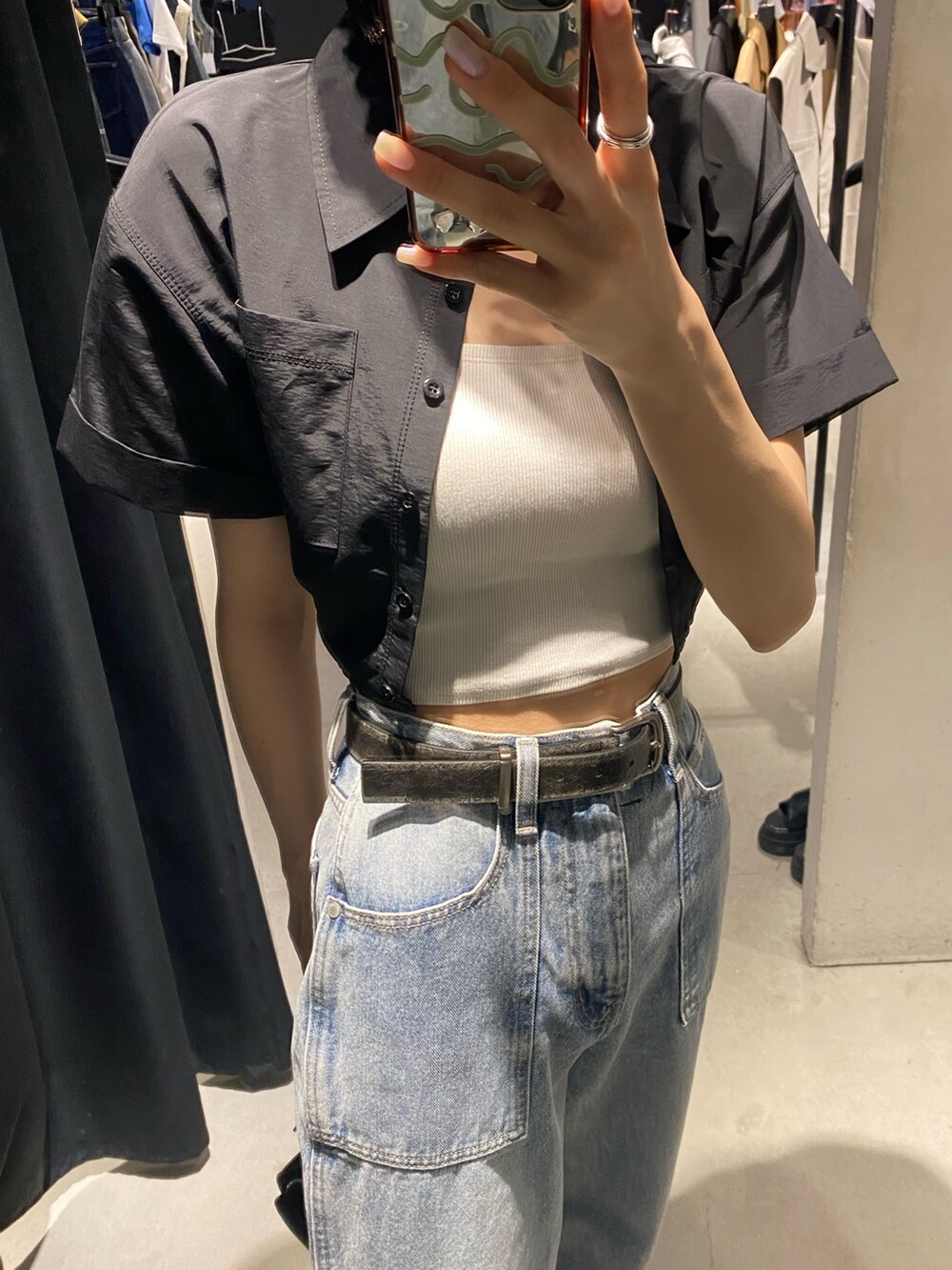 ブラック系のサンダル、ブルー系のデニムパンツ、ブラック系のシャツ/ブラウスを着用したレディースの夏コーディネートの6枚目の写真