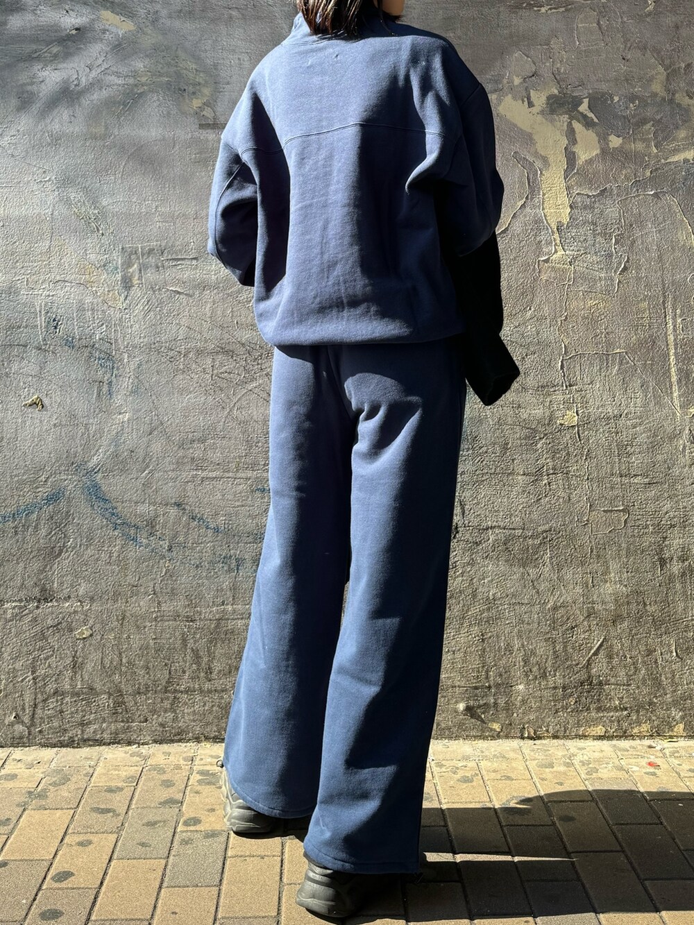 ブルー系のTシャツ/カットソー、ブルー系のTシャツ/カットソー、ブラック系のチェスターコートを着用したレディースの秋コーディネートの5枚目の写真