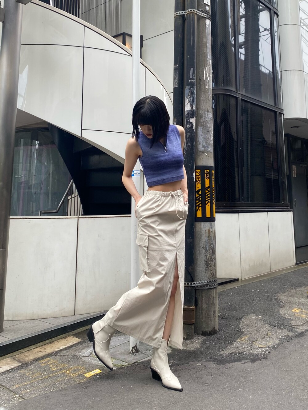 ホワイト系のブーツ、ホワイト系のスカート、ブルー系のタンクトップを着用したレディースの春コーディネートの2枚目の写真