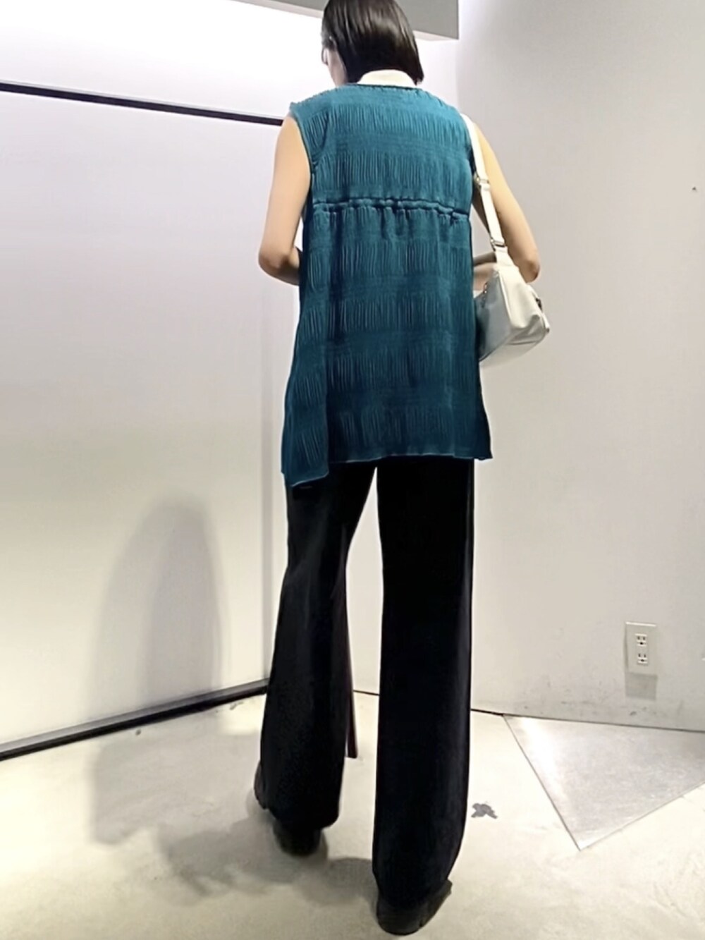 ブラック系のブーツ、ホワイト系のハンドバッグ、ブルー系のTシャツ/カットソーを着用したレディースの夏コーディネートの3枚目の写真