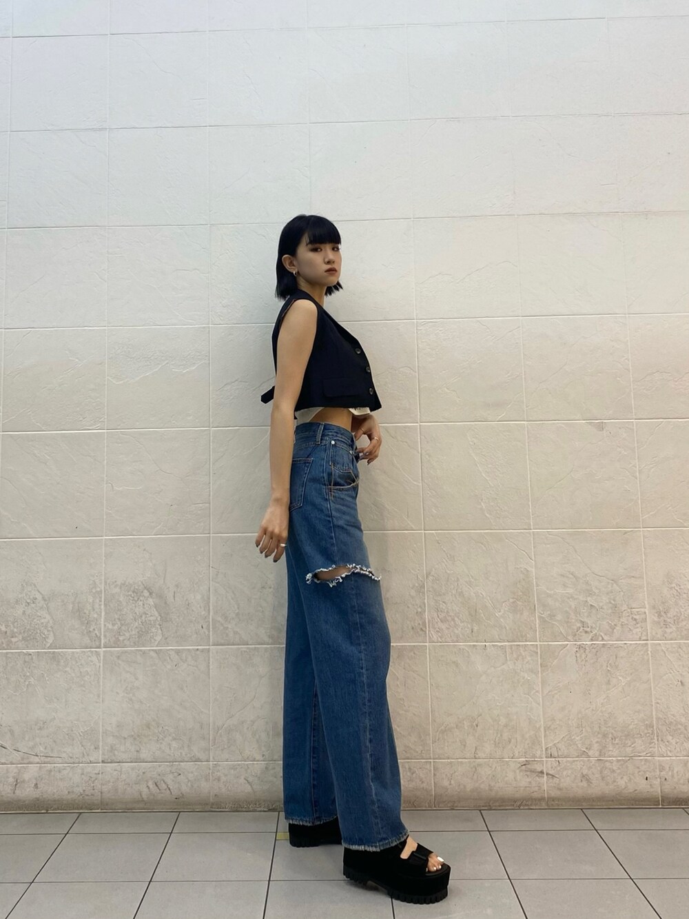 ブラック系のサンダル、ブルー系のデニムパンツ、ホワイト系のニット/セーターを着用したレディースの夏コーディネートの4枚目の写真